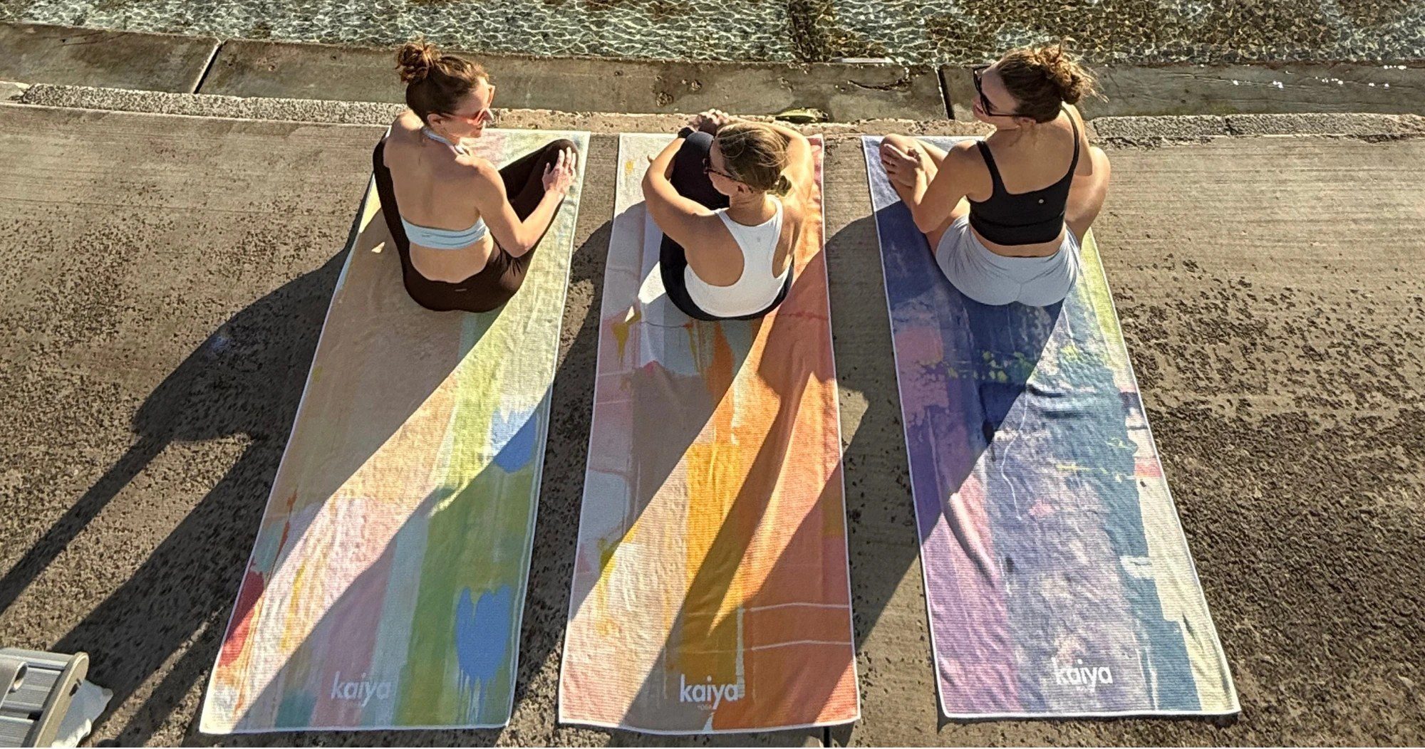 Three friends sitting on Kaiya towels
